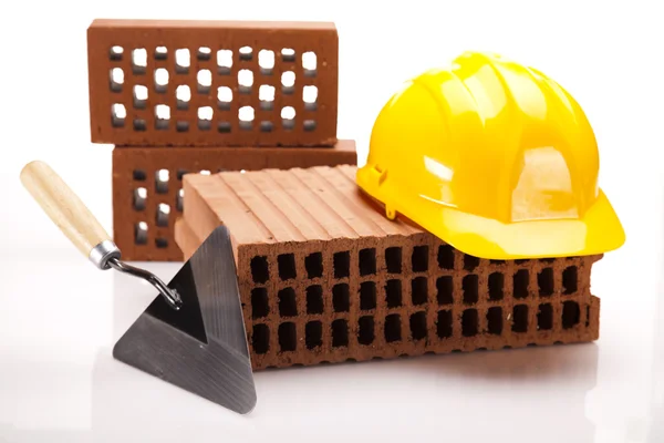 Hard hat with bricks and trowel — Stock Photo, Image