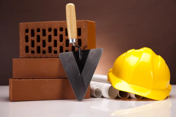 Hard hat with bricks and trowel — Stock Photo, Image