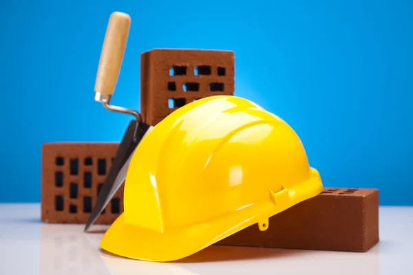 Hard hat with bricks and trowel — Stock Photo, Image
