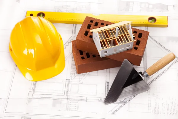 Hard hat with bricks and trowel — Stock Photo, Image