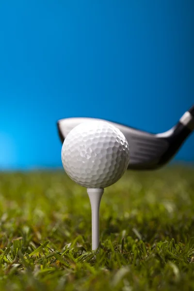 Pelota de golf sobre hierba verde sobre fondo azul — Foto de Stock