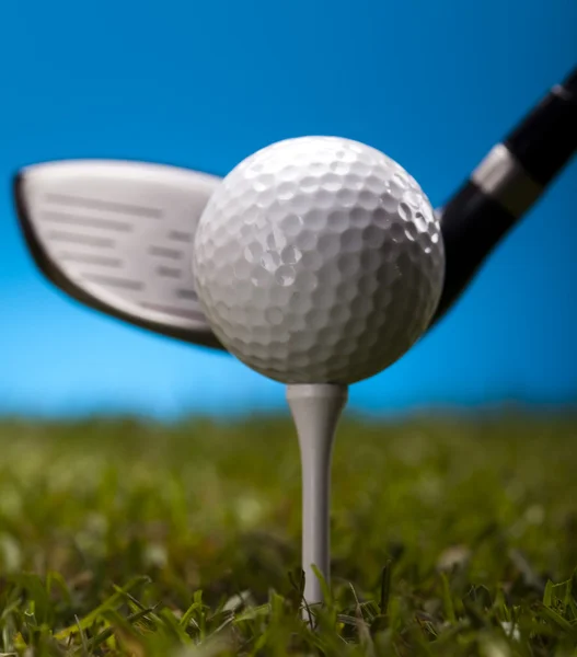 Pelota de golf sobre hierba verde sobre fondo azul — Foto de Stock