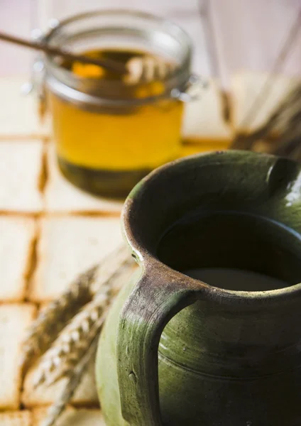 Milk in a jug and honey — Stock Photo, Image