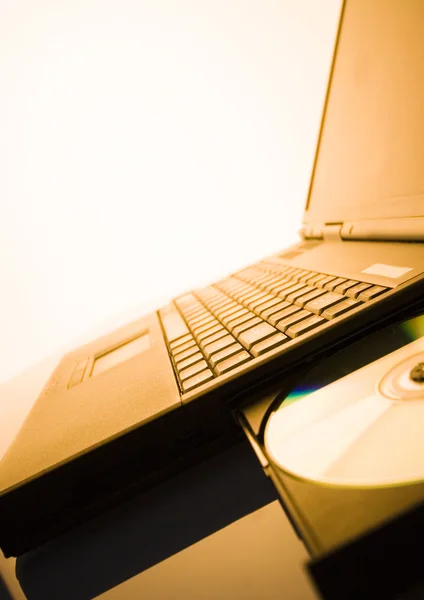 Laptop with a disc — Stock Photo, Image