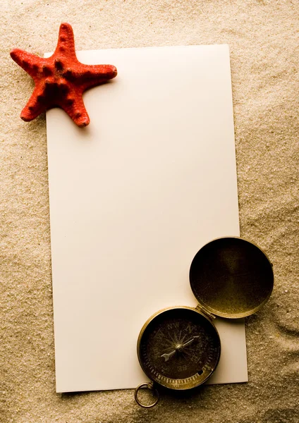 Раковина, песок и лист бумаги — стоковое фото