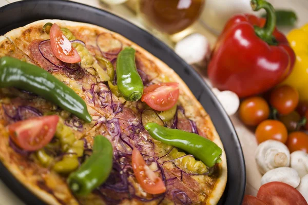 Vegetables with a pizza — Stock Photo, Image