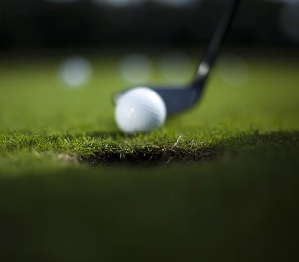 Мяч для гольфа на зеленом лугу, водитель — стоковое фото