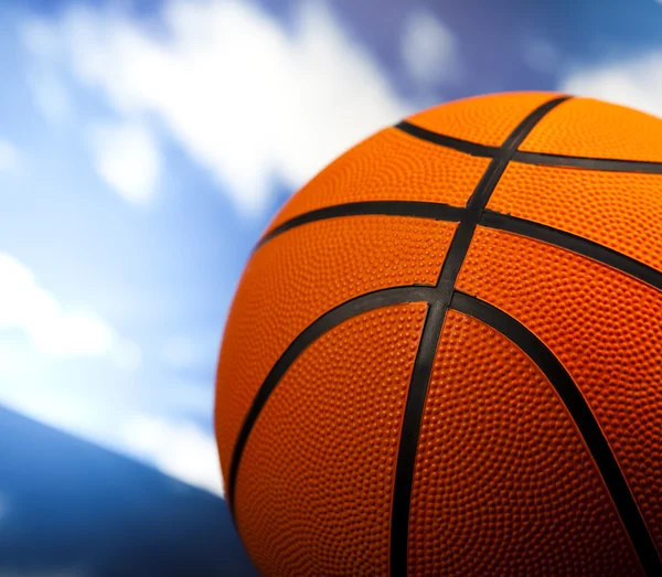 Basketball ball over blue sky background — Stock Photo, Image