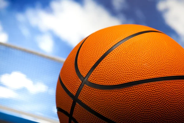 Basketball ball over blue sky background — Stock Photo, Image