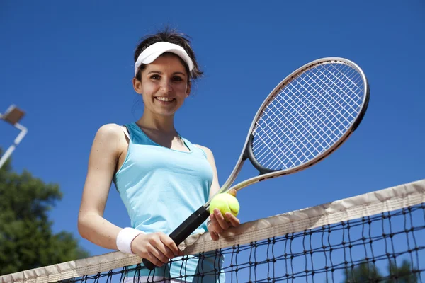 Meisje berust op een tennis netto — Stockfoto