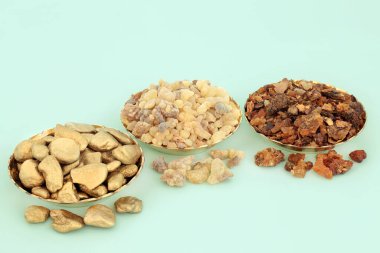 Kâselerde altın tütsü ve reçine kompozisyonu ve gevşek. Üç Bilge Adam tarafından İsa 'ya İsa' nın doğumunda verilen Hristiyan dinindeki hediyelerin sembolleri. Pastel turkuaz arka planda.