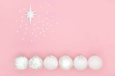 Beytüllahim yıldızının sembolü ve pembe arka planda kar taneleri olan beyaz noel ağacı süslemeleri. Tatil sezonu için en az soyut kompozisyon. Üst manzara, düz yatış. Boşluğu kopyala.