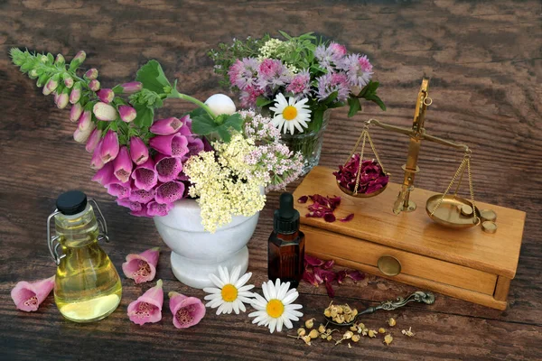 Herbal plant based medicine preparation with herbs, flowers for aromatherapy essential  oil with scales. Natural health care concept for alternative healing. Top view, flat lay on rustic wood.