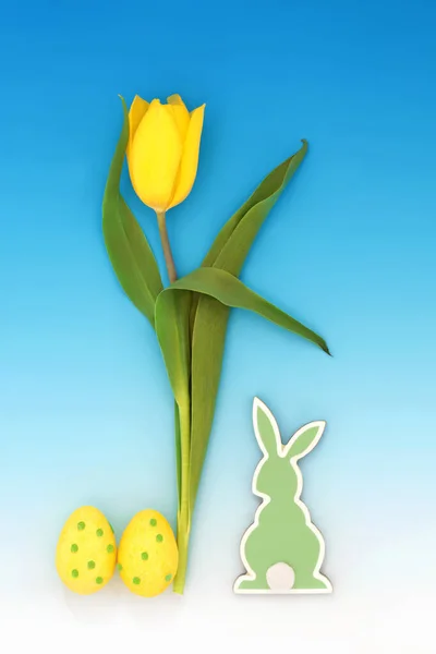 复活节构图 带有彩蛋 兔子和黄色郁金香花的符号 呈渐变蓝色背景 春季和复活节抽象设计概念 — 图库照片