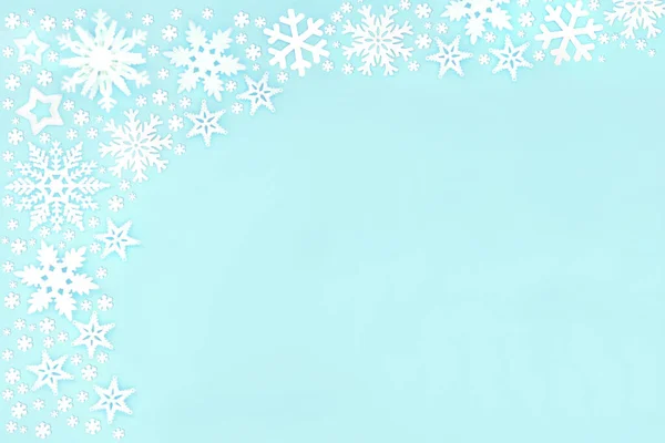 青い背景にクリスマスの雪の結晶と星の背景境界組成 ホリデーシーズンのためのお祭りのレイアウト フラットレイアウトトップビュー コピースペース — ストック写真