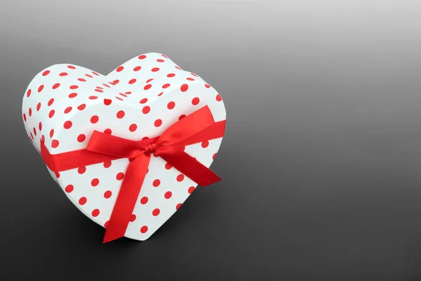 バレンタインデーハート型の赤い弓とポルカドットギフトボックス 誕生日 記念日や母の日の贈り物のためのロマンチックな概念を与える グラデーショングレーの背景にコピースペース — ストック写真