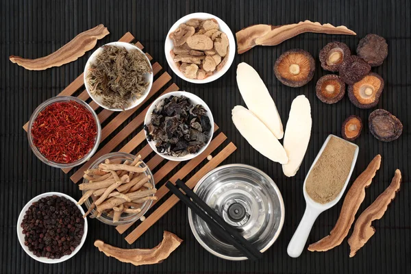 Chinese moxibustion treatment with moxa sticks, herbs and spice used in traditional herbal plant medicine. Natural health care concept. On bamboo background. 