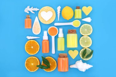 Nemlendirici, losyon, sabun, sünger, eski yapraklandırma tuzu ve deniz kabuklarıyla yapılan tonik cilt bakımı için taze portakal ve limonlu narenciye meyvesi. Doğal sağlık bakım cilt konsepti. Mavi üzerine.
