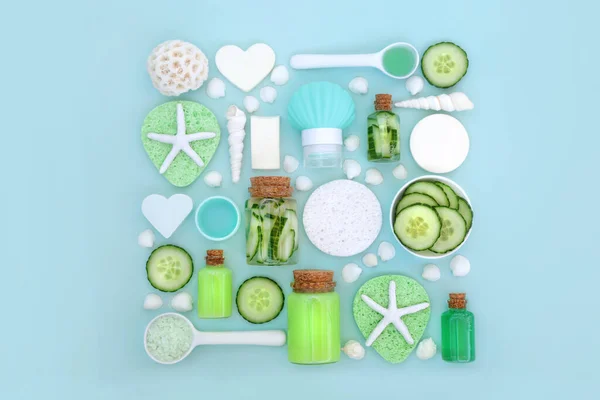 Healing natural beauty treatment concept for skincare and body care with fresh cucumber and cleansing products. Square design on pastel blue with decorative seashells, top view, copy space.