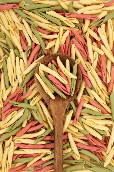 オリーブの木のスプーンでFusili Pulgiesiトライ色のパスタと抽象的な背景を形成します 健康的なイタリアの炭水化物の食品コンセプト — ストック写真