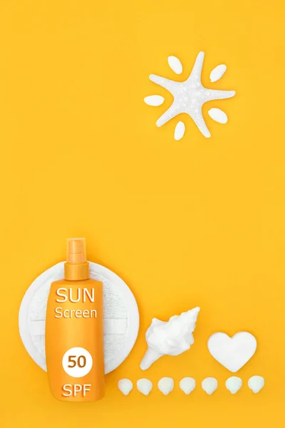 Suntan lotion bottle SPF factor 50 for skin cancer protection with exfoliation scrub, soap, abstract starfish sun and decorative seashells. Protective anti cancer healthcare concept. On yellow.