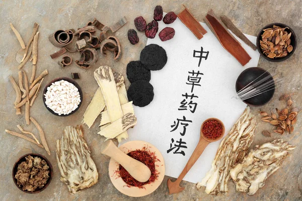 Chinese herbal plant medicine with acupuncture needles, herbs, spice with calligraphy script on rice paper. Natural healthcare concept. Translation reads as Traditional Chinese herbal therapy.