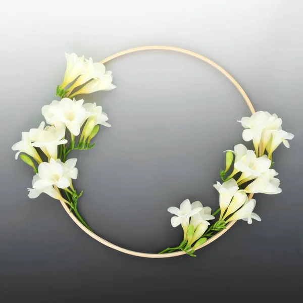 Freesia flower wreath with wooden frame. Natural beautiful minimal round shape symbol on gradient grey. Minimal nature concept.