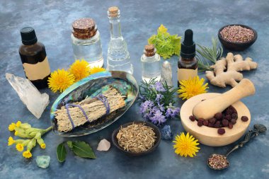Cleansing ritual ingredients with sage smudge stick, crystals, essential oils, herbs and flowers. Shamanic Native American and pagan magical healing plant remedy, esoteric spiritual concept.