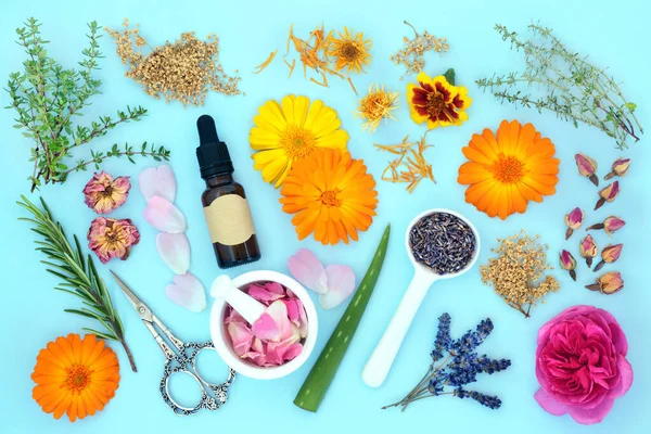 Aromatherapy essential oil preparation with summer flower and herbs. Natural plant based flower remedy skincare treatment. Can ease psoriasis, eczema, acne and wounds. On blue background.