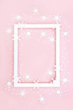 Yeni yıl Noel arkaplan sınırı beyaz kar tanesi süslemeleri ile birlikte pastel pembenin üzerinde. Tebrik kartı, etiket, hediye etiketi, menü veya davet için soyut festival tasarımı.