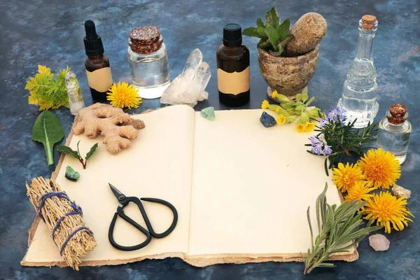 Open old hemp recipe notebook, natural pagan wiccan herbal plant and flower  remedy preparation. Herbs, flowers, crystals, aromatherapy essential oils and smudge stick. Nature still life