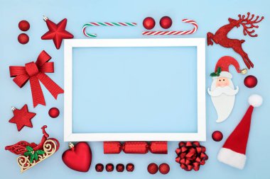 Kırmızı retro oyuncak ağaç süslemeleri ve sembollerle mavi renkteki Noel soyut arka plan kenarı. Beyaz çerçeveli eğlenceli kompozisyon. Tatil sezonu için canlı bir eğlence konsepti. Düz yatıyordu. 