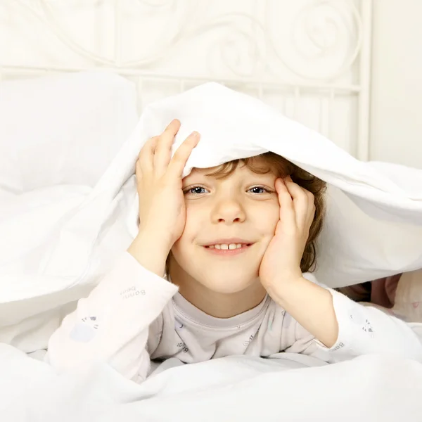 Criança feliz na cama — Fotografia de Stock