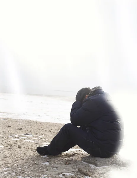 Eenzame man zittend op zand — Stockfoto