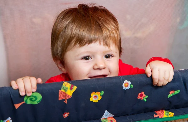 Baby girl standing in cot — Stock Photo, Image