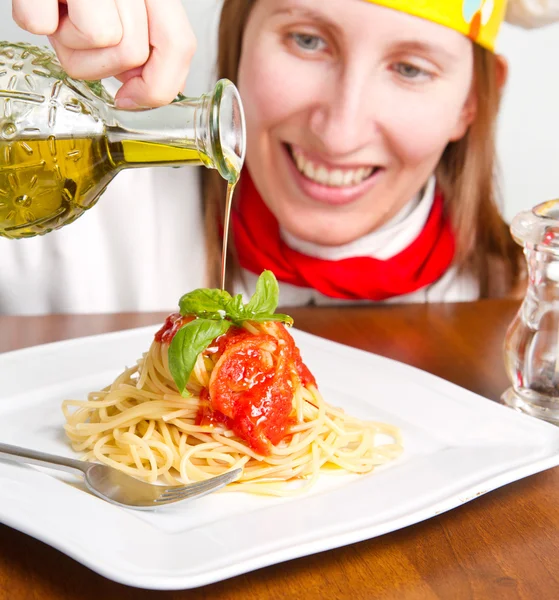 Lächelnder Koch garniert ein italienisches Nudelgericht mit Käse — Stockfoto