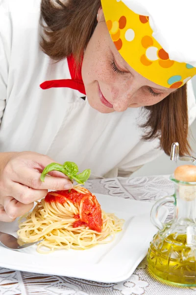 Cuoco sorridente guarnire un piatto di pasta italiana con formaggio — Foto Stock