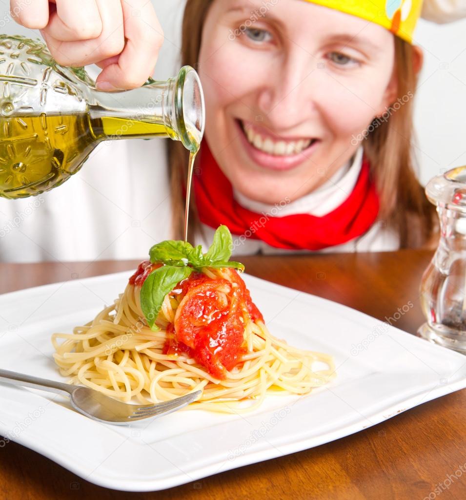 Smiling chef garnish an Italian pasta dish with cheese — Stock Photo