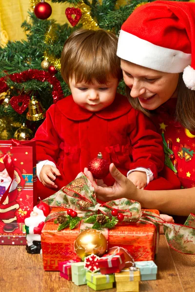 Young mother with baby at Christmas tree Royalty Free Stock Photos