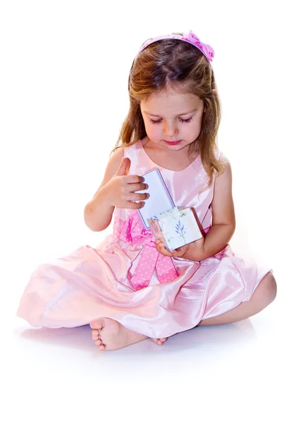 Fröhliches kleines Mädchen mit fliederfarbenem Geschenk in der Hand — Stockfoto