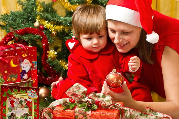 Jonge moeder met baby op kerstboom — Stockfoto