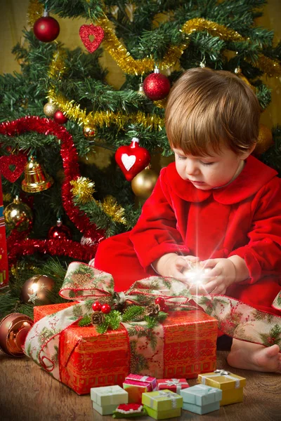 Baby spelen met huidige vak kerstboom — Stockfoto