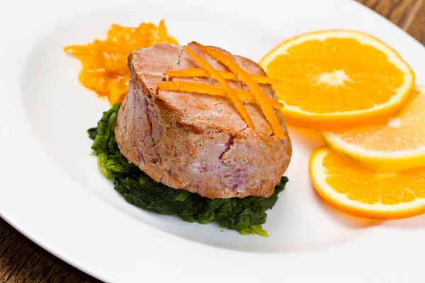 Rántott tonhal szelet friss narancs, narancssárga mártással és spenót — Stock Fotó