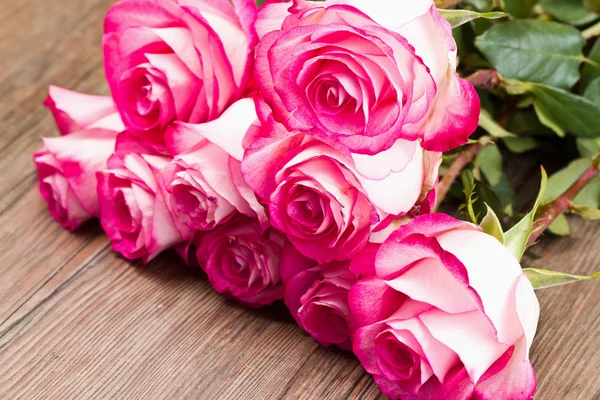 Hermosas rosas rosadas sobre fondo de madera — Foto de Stock