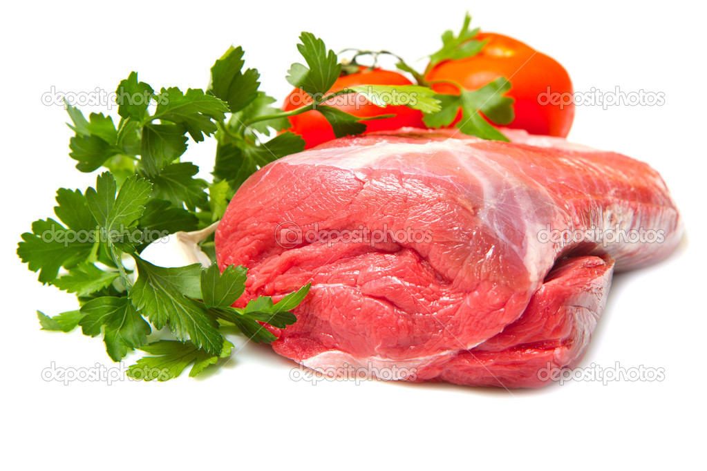 Piece of raw beef with parsley and tomatoes - isolated on white