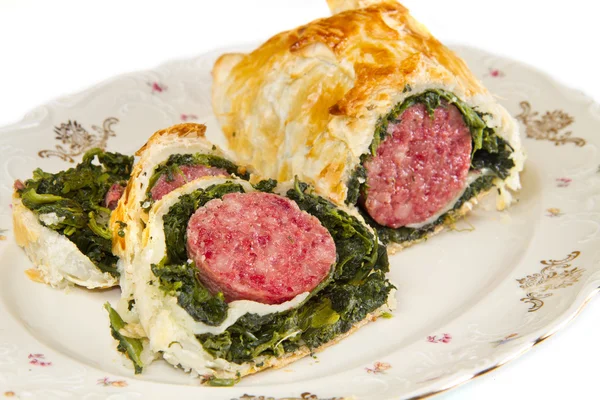 Italian cotechino in crust with spinach — Stock Photo, Image
