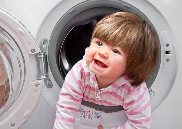 Meisje van de baby in de wasmachine — Stockfoto
