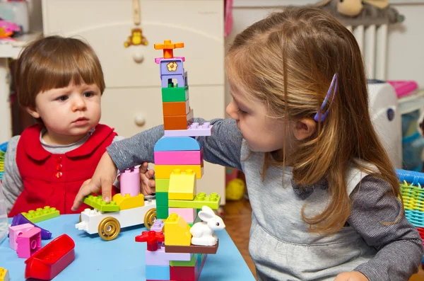 Little girls playing with building bricks — Stock Photo, Image