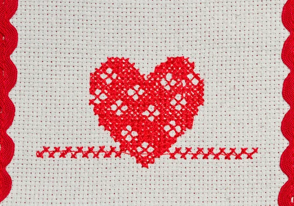 Červené srdce vyšívané v cross stitch na plátně — Stock fotografie