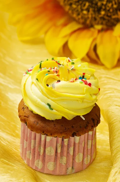 Delicioso bolo de xícara de baunilha com cobertura amarela — Fotografia de Stock